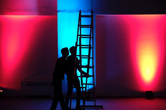 LED Wall Operator man in black jacket standing on black ladder