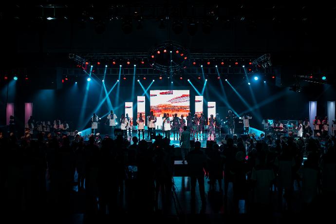 people standing on stage with lights turned on during night time